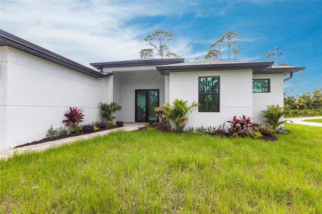 view of front of home with stucco siding and a front yard