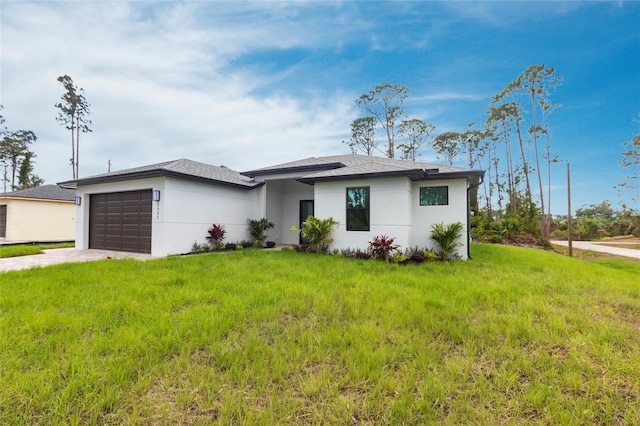 prairie-style home featuring an attached garage, stucco siding, a front yard, and driveway