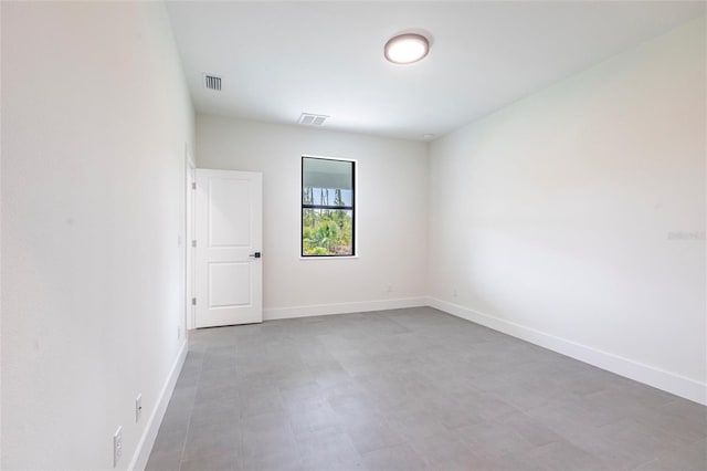spare room with baseboards and tile patterned floors