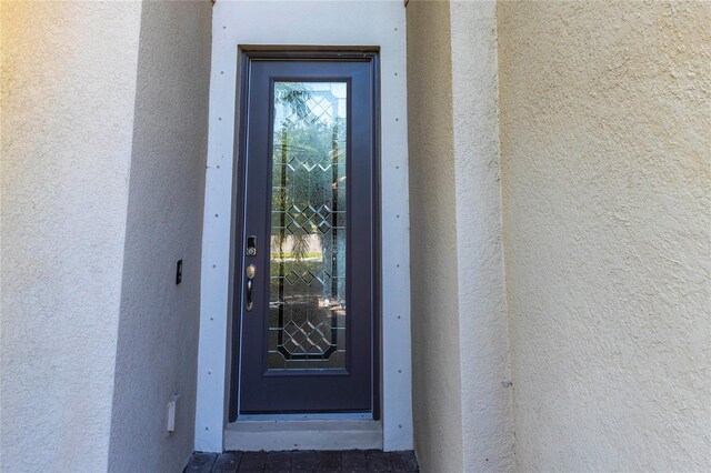 view of exterior entry with stucco siding