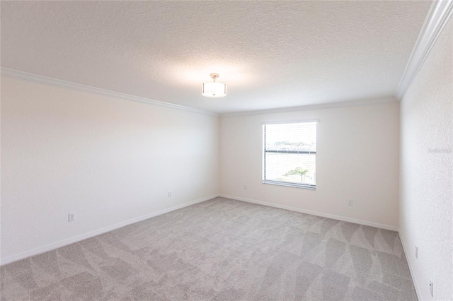 spare room with a textured ceiling, crown molding, baseboards, and light carpet