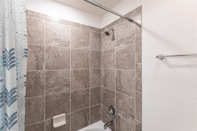 full bath featuring shower / bath combo with shower curtain and a textured wall