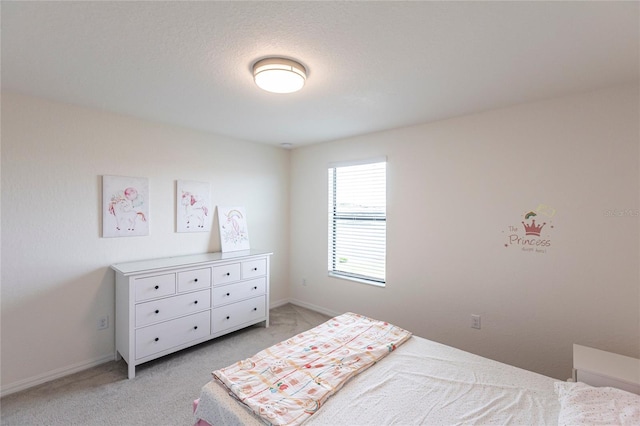 bedroom with light colored carpet and baseboards