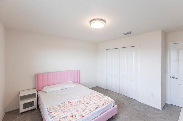 carpeted bedroom with a closet, visible vents, and baseboards