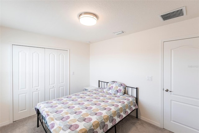 bedroom featuring visible vents, a closet, and light colored carpet