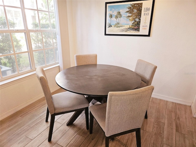 dining area with baseboards and light wood-type flooring