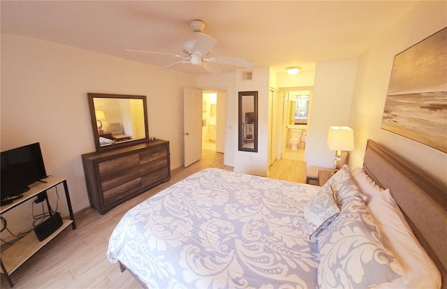 bedroom with light wood-type flooring, connected bathroom, and a ceiling fan