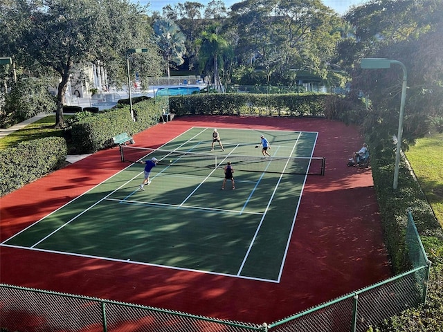 view of tennis court with fence and community basketball court