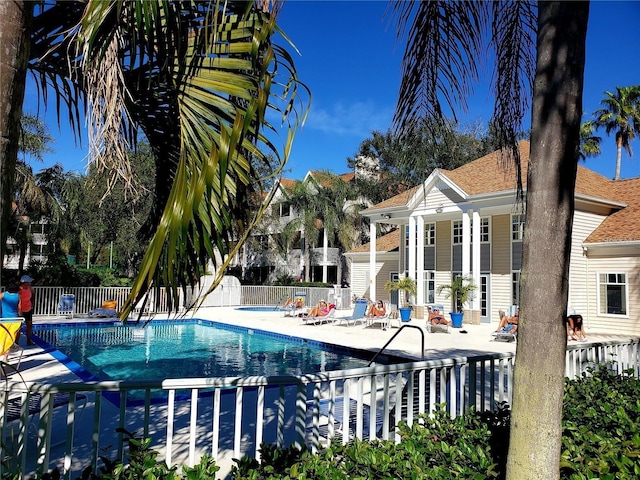 community pool featuring fence and a patio area