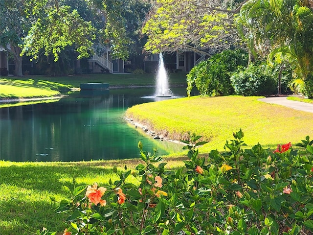view of community featuring a water view and a yard