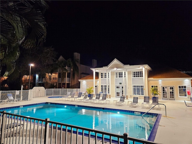 850 S Tamiami Trl Unit 529, Sarasota, FL 34236 - pool at night featuring french doors, fence, a patio area, and a community pool
