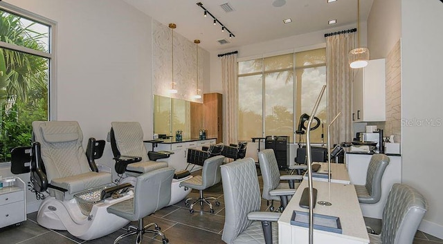 office featuring dark tile patterned flooring, visible vents, and track lighting