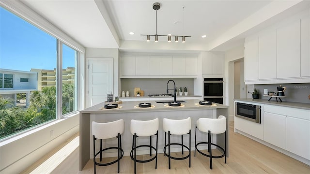 8800 Midnight Pass Rd, Sarasota, FL 34242 - kitchen with stainless steel microwave, modern cabinets, healthy amount of natural light, a kitchen breakfast bar, and recessed lighting