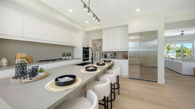 8800 Midnight Pass Rd, Sarasota, FL 34242 - kitchen featuring high quality fridge, a breakfast bar area, light wood-type flooring, gas stovetop, and light countertops