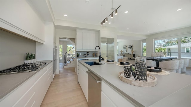 8800 Midnight Pass Rd, Sarasota, FL 34242 - kitchen with stainless steel appliances, healthy amount of natural light, light wood-style flooring, white cabinetry, and recessed lighting