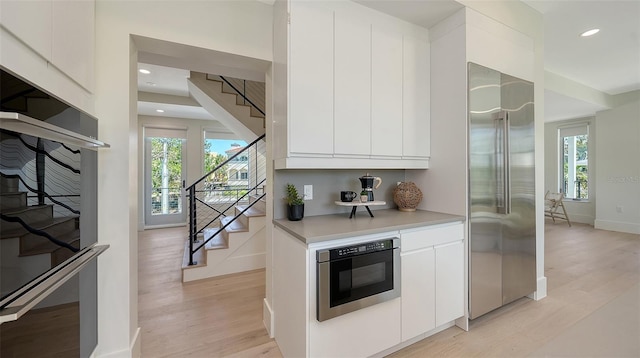 8800 Midnight Pass Rd, Sarasota, FL 34242 - kitchen with built in appliances, modern cabinets, light wood-type flooring, plenty of natural light, and recessed lighting