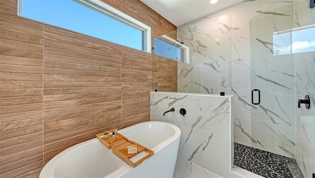 8800 Midnight Pass Rd, Sarasota, FL 34242 - full bath featuring tile walls, healthy amount of natural light, a marble finish shower, and a freestanding tub