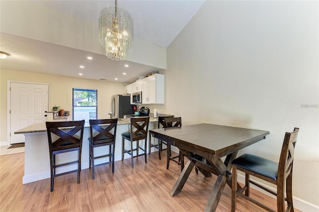dining room with baseboards, a chandelier, light wood finished floors, and recessed lighting