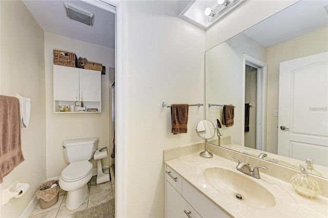 bathroom with toilet, vanity, tile patterned floors, and baseboards
