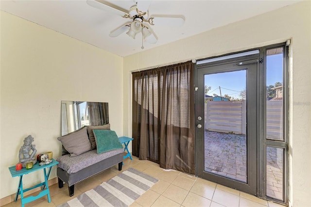 doorway featuring ceiling fan and tile patterned floors