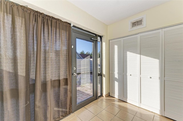 doorway with visible vents and light tile patterned floors