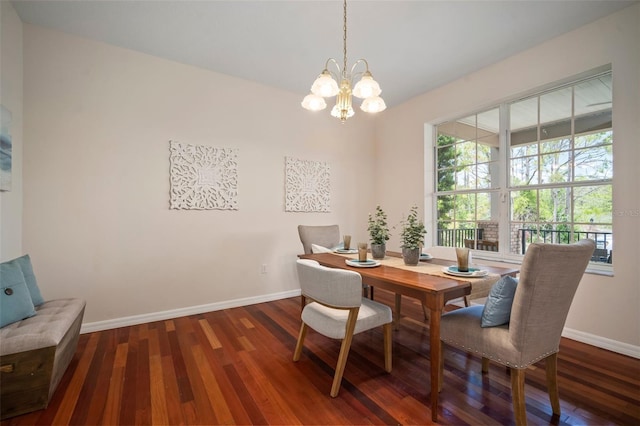 dining area featuring wood finished floors, a healthy amount of sunlight, baseboards, and a notable chandelier