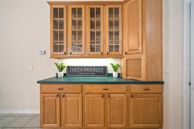 bar featuring baseboards and light tile patterned floors