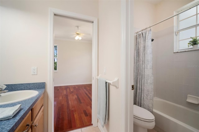 bathroom with toilet, shower / bath combo with shower curtain, wood finished floors, vanity, and ornamental molding