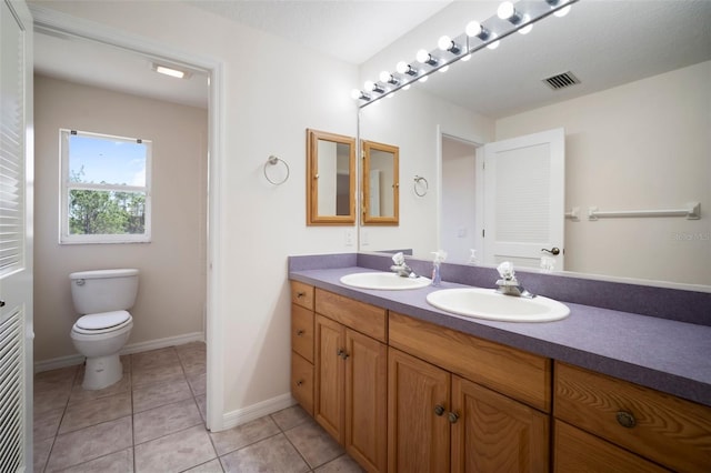 full bath featuring double vanity, visible vents, toilet, and a sink