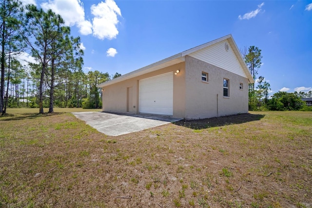 view of home's exterior featuring stucco siding, driveway, a yard, and a garage