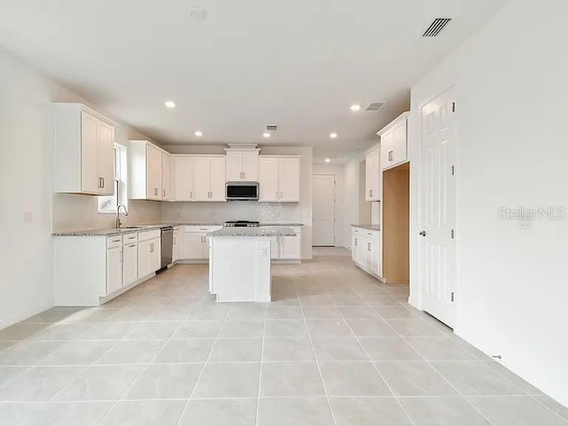 kitchen featuring white cabinets, appliances with stainless steel finishes, a sink, and visible vents