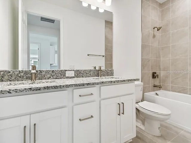 bathroom featuring double vanity, visible vents, toilet, and a sink
