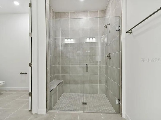 bathroom featuring toilet, baseboards, recessed lighting, tile patterned flooring, and a shower stall