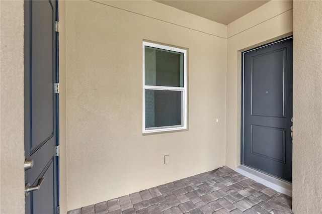 doorway to property featuring stucco siding