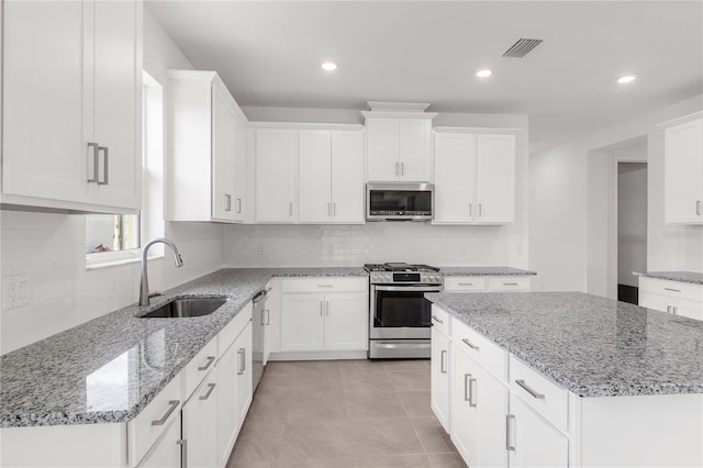 kitchen featuring visible vents, appliances with stainless steel finishes, decorative backsplash, and a sink
