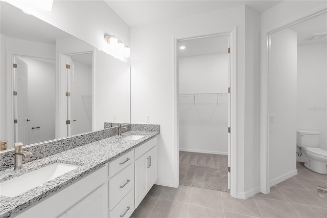 full bath featuring a walk in closet, visible vents, toilet, and a sink