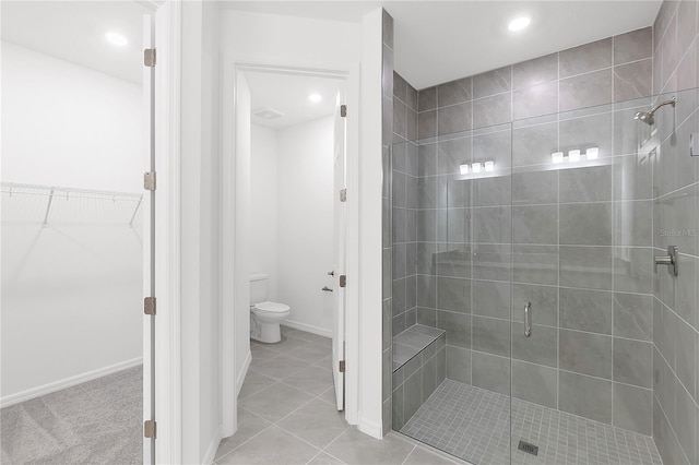bathroom featuring a shower stall, tile patterned floors, a spacious closet, toilet, and recessed lighting