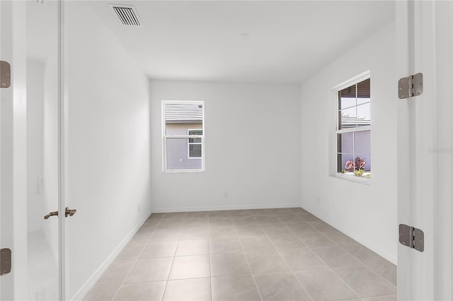 spare room with visible vents, baseboards, and light tile patterned floors