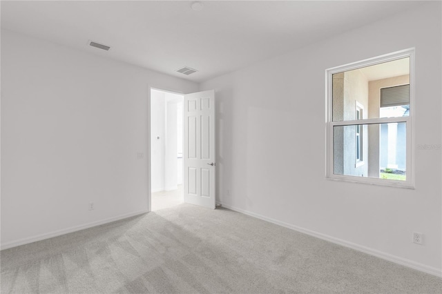 carpeted empty room with baseboards and visible vents