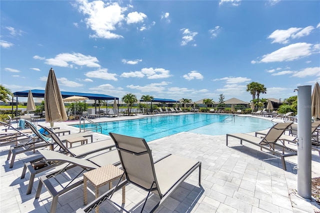 community pool featuring a patio and fence