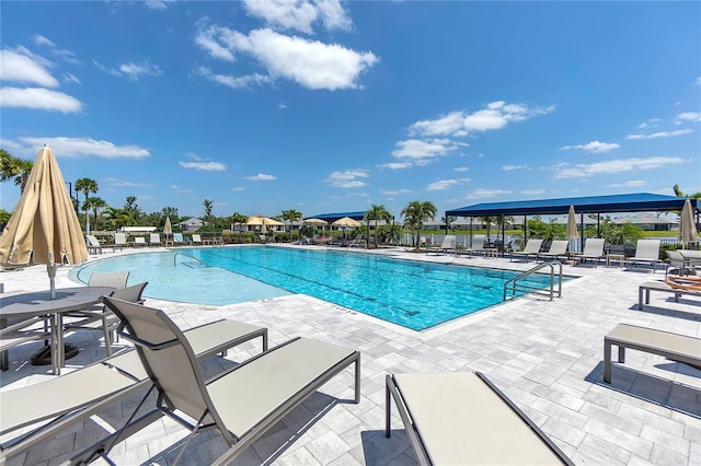 community pool featuring fence and a patio area