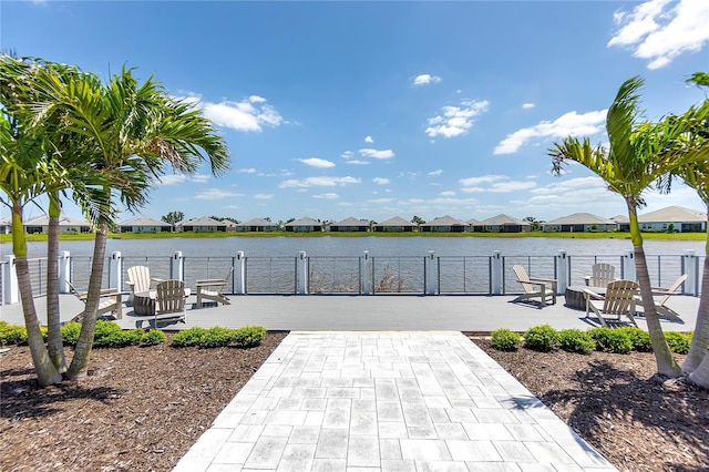 dock area with fence, a patio area, a residential view, and a water view