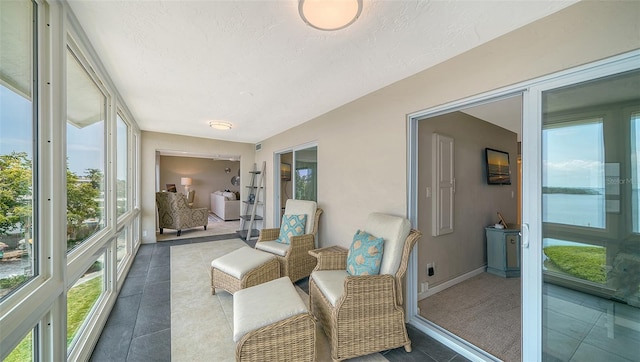 sunroom / solarium featuring tile patterned flooring, baseboards, and a textured ceiling