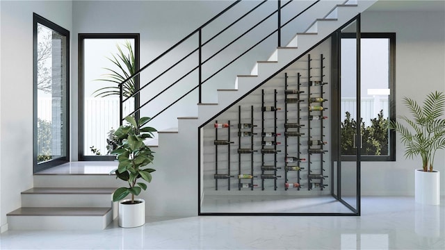 wine area with baseboards, marble finish floor, and plenty of natural light