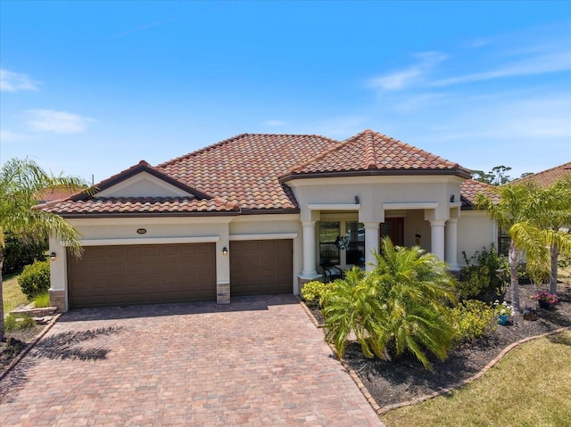 20655 Valprato Ct, Venice, FL 34293 - mediterranean / spanish home featuring stucco siding, an attached garage, decorative driveway, and a tiled roof
