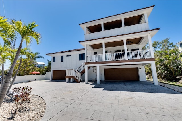 coastal home with stairway, driveway, and a garage