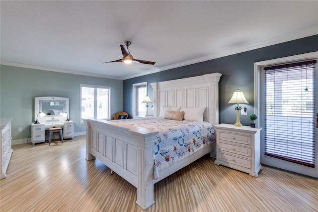 bedroom featuring a ceiling fan, baseboards, and crown molding