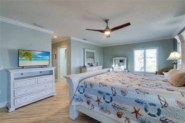 bedroom with baseboards, light wood-style flooring, visible vents, and crown molding