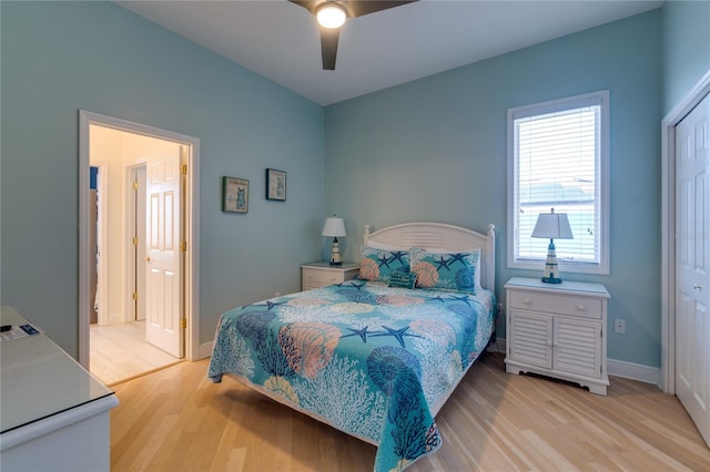 bedroom featuring light wood-type flooring, a ceiling fan, baseboards, and a closet
