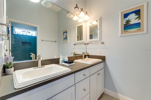 full bath featuring baseboards, a sink, and double vanity
